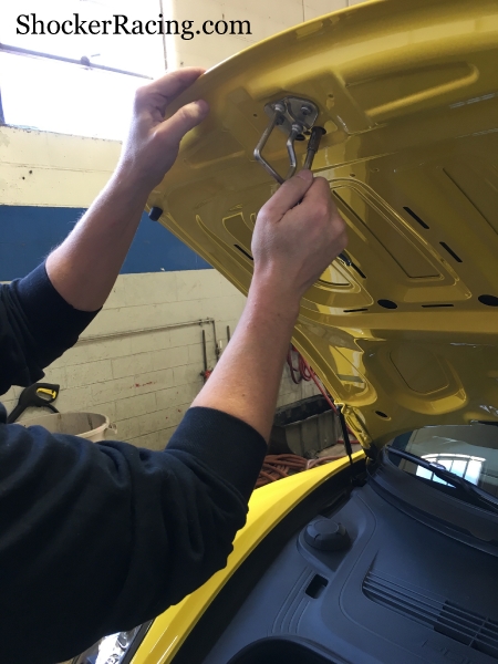 Remove the two 8mm speed nuts that hold the Porsche Cayman Hood Crest in place